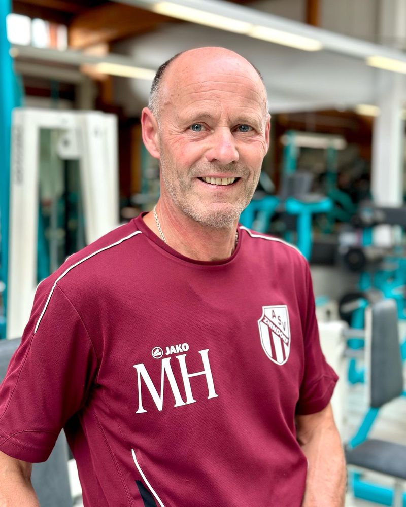Mitglied im Trikot lächelt in der Trainingshalle